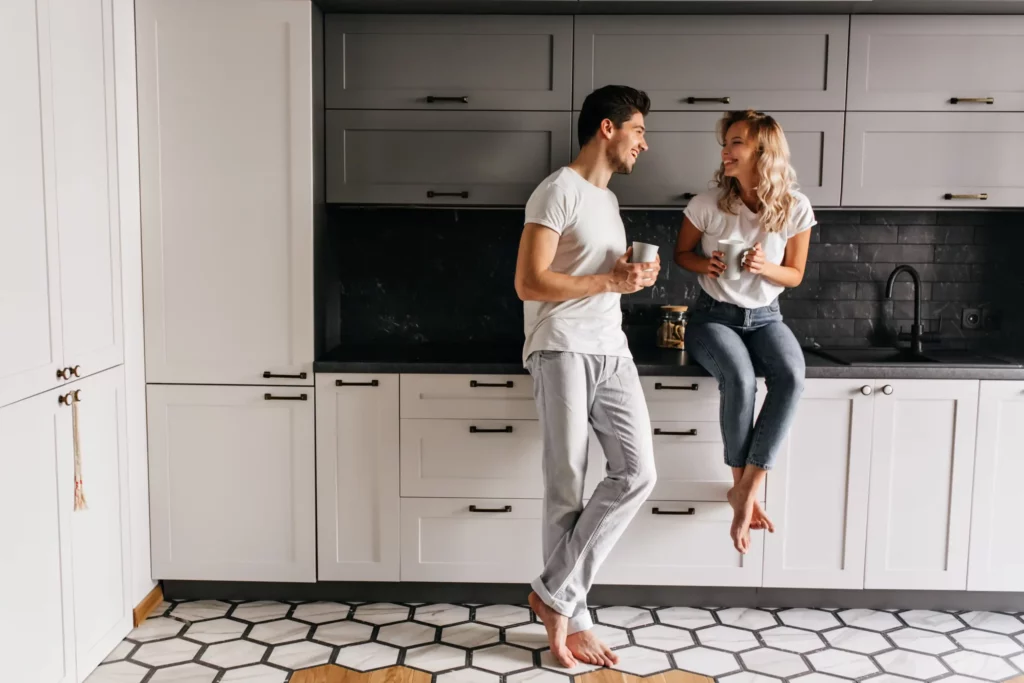 good humoured young man drinking tea kitchen with stylish interior indoor portrait carefree couple enjoying breakfast scaled